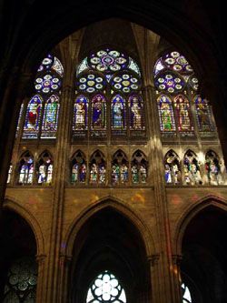 Vue du triforium et des fentres hautes du vaisseau central. Avec la reconstruction du XIIIe sicle, le triforium n'est plus aveugle, il est ajour. Les fentres hautes, avec leurs quatre lancettes surmontes de trois roses, prsentent une galerie des rois et reines de France. Cette srie de vitraux, dessine par Franois Debret, date du XIXe sicle.   CMN